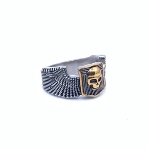 Detail of vintage punk ring showing gold skull shield and silver eagle wing textures