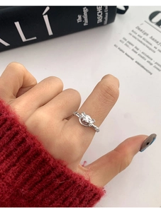 Détail d'une bague planète argentée avec cristal sur fond de livre de mode élégant