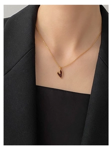 Nahaufnahme einer minimalistischen S925 Silberkette mit kleinem tiefrotem Herzanhänger