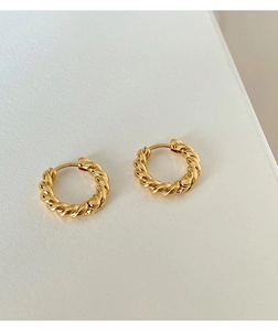 Detail view of twisted gold hoop earrings showing the intricate rope design and polished finish