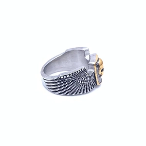 Close-up of retro punk ring with silver wings and a golden skull detail decoration