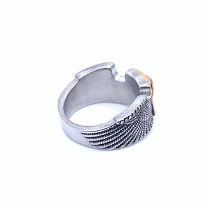 Macro side view of retro punk steel ring with gold relief and feather textures
