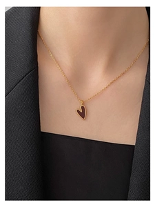 Nahaufnahme der minimalistischen Gold-Silberkette mit dunkelrotem Herzanhänger am Model