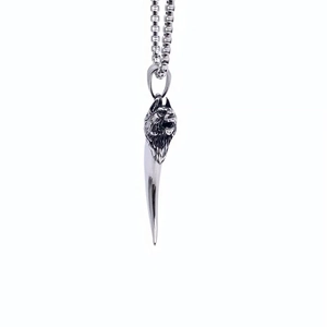 Vue détaillée du pendentif tête de loup avec dent en argent et chaîne à billes carrées