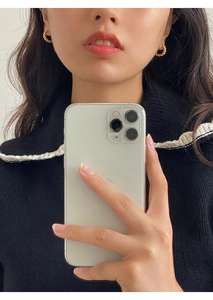 Golden twisted rope hoop earrings showcased on a model in a mirror selfie style