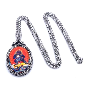 Vue détaillée du pendentif Mahakala avec bordure argentée vintage et chaîne en acier