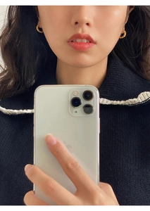 Close-up of a model wearing twisted gold hoop earrings with a textured braid design