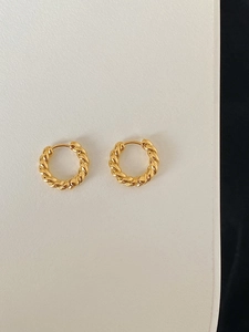 Detailed view of golden twisted rope hoop earrings with vintage braided texture and clasp