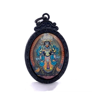 Detalle del colgante thangka negro con patrón de deidad étnica y marco tallado