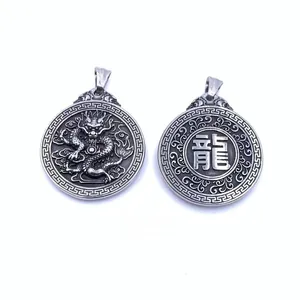 Detailed macro view showing the double-sided dragon relief and engraved character on a steel pendant