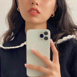 Minimalist golden twisted hoop earrings with spiral texture shown on a female model