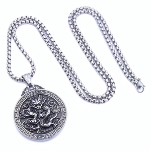 Macro view of stainless steel dragon relief pendant with traditional cloud patterns