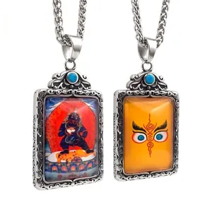 Pendentif bouddhiste double face avec incrustation de turquoise et relief détaillé