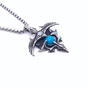 Macro detail of vintage titanium steel eagle pendant with turquoise stone inlay