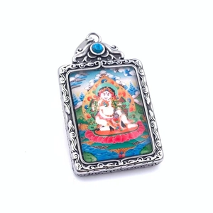 Détail macro du pendentif thangka bouddhiste avec relief en argent et perle turquoise