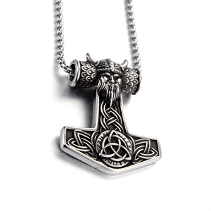 Macro detail of Mjolnir pendant with Viking warrior head and Celtic knotwork engraving