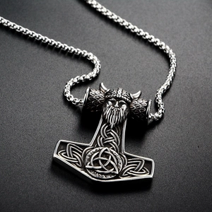 Macro shot of Viking Thor's Hammer pendant with intricate Celtic knots and Odin face