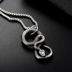 Détail du pendentif serpent argenté rétro avec écailles texturées et chaîne box sur pierre noire