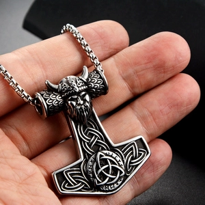 Detailed view of Viking Thor's hammer pendant with warrior head and Celtic knotwork