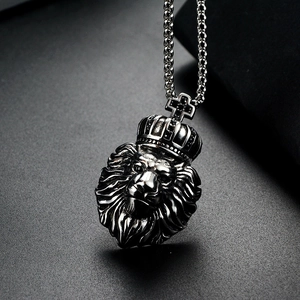 Gros plan d'un pendentif tête de lion vintage avec couronne et chaîne à billes en métal