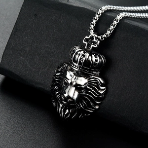 Détail macro du pendentif tête de lion avec couronne en zircon noir et texture en acier