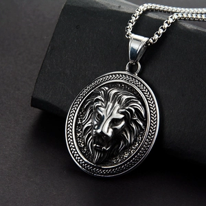 Macro view of silver lion head embossed oval pendant with durable box chain detail