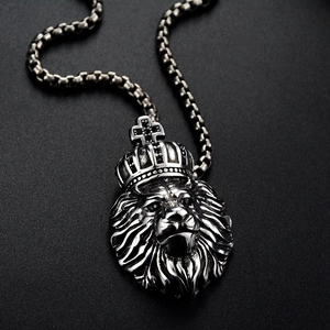 Détail du pendentif tête de lion en argent avec couronne et pierres noires sur chaîne