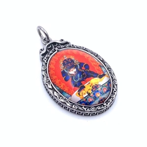 Gros plan d'un pendentif Thangka vintage en acier titane avec gravures métalliques fines