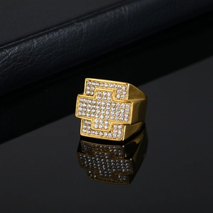 Bague hip hop en acier titane doré avec motif croix et cristaux sur support noir