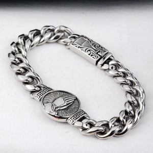 Detailed view of silver Cuban chain bracelet featuring prayer hands and Greek key patterns