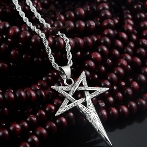 Macro detail of pentagram and evil eye engraving on vintage stainless steel necklace
