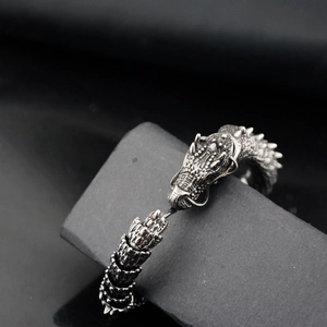 Macro detail of vintage dragon bone steel bracelet featuring intricate scales and dragon head