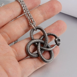 Pendentif nœud de serpent vintage en acier inoxydable avec chaîne spiga sur la main