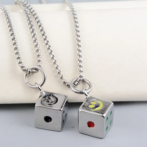 Detailed macro view of polished steel dice pendants with smiling face and colored dots