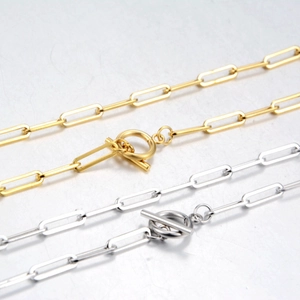 Détail de chaînes trombones en argent et or avec un fermoir à bascule classique