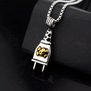 Detail of punk skull plug pendant with silver box chain on black texture background