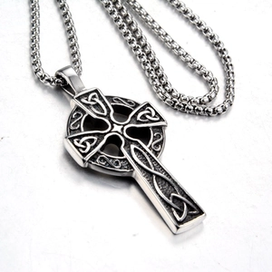 Macro detail of antique silver Celtic knot cross pendant on a round pearl chain link
