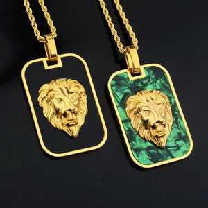 Detail of lion head relief pendants in gold with black and green textured backgrounds