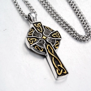 Detailed close-up of a silver Celtic cross pendant with golden knot inlay on a thick chain