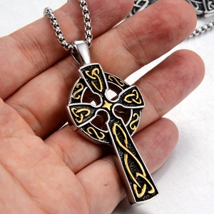 Detailed macro view of two-tone Celtic cross pendant in silver and gold finish steel
