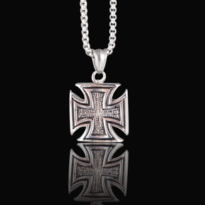 Detailed macro view of iron cross pendant necklace with oxidized vintage finish