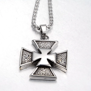 Macro detail of silver iron cross pendant with honeycomb texture and thick mesh chain