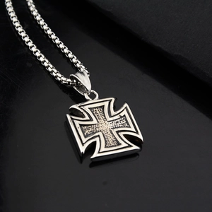 Macro shot of vintage iron cross pendant with textured metal finish and box chain
