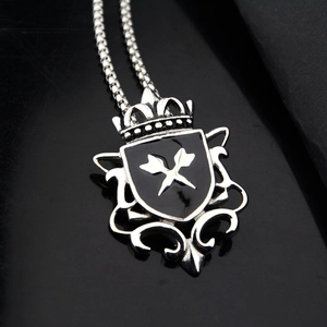 Detail of vintage shield pendant with black enamel inlay on polished box chain