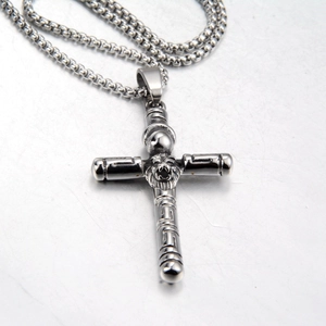 Dettaglio del ciondolo a croce testa di leone argento con motivi e catena veneziana
