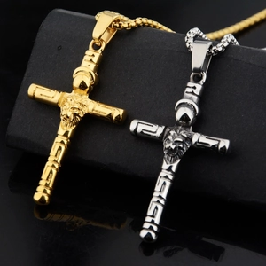 Dettaglio dei ciondoli a croce con testa di leone in oro e argento e greca classica