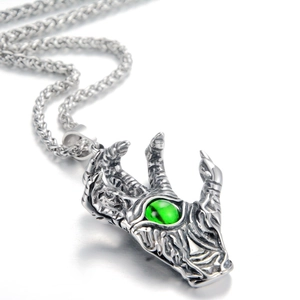 Detailed close-up of a dragon claw pendant holding a green gemstone on a wheat chain