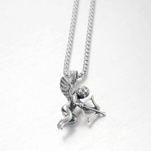 Detailed macro shot of Cupid angel pendant with bow on a textured steel box chain
