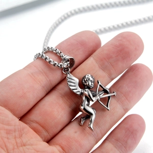 Macro shot of silver cupid angel pendant in stainless steel with retro vintage details