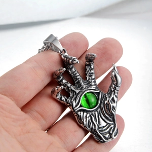 Detailed macro shot of gothic silver claw hand pendant with vibrant green opal stone